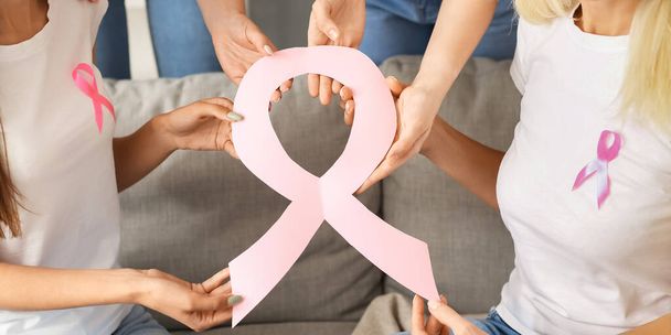 Women with pink paper ribbon. Breast cancer awareness concept - Foto, Imagen