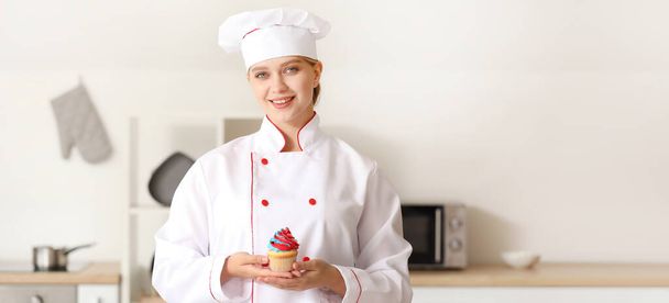 Női cukrász ízletes cupcake a konyhában - Fotó, kép