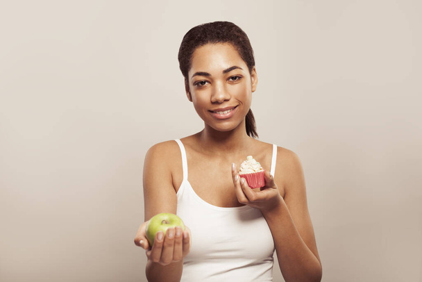 Idea zdrowego odżywiania. Ładna kobieta z portretem owocowym i tortowym - Zdjęcie, obraz
