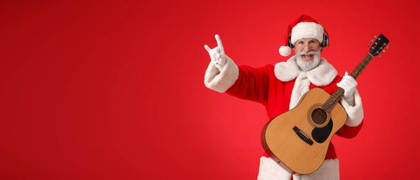 Крутой Санта-Клаус играет на гитаре на красном фоне с пространством для текста - Фото, изображение