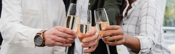 Cropped view of multiethnic business people clinking champagne in office, banner  - Foto, imagen