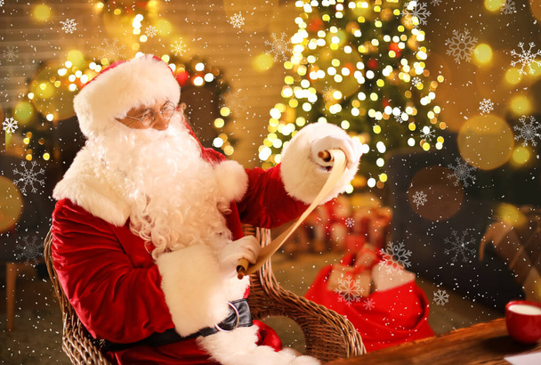 Санта Клаус читает письмо дома в канун Рождества - Фото, изображение