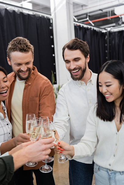 Cheerful interracial business people clinking champagne during corporate party  - Foto, immagini