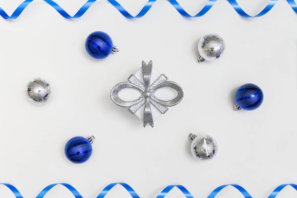 Composition hivernale en coffret cadeau, boules bleues et argentées sur fond blanc. Noël et nouvelle année concept. Style minimal. Vue de dessus. Pose plate - Photo, image