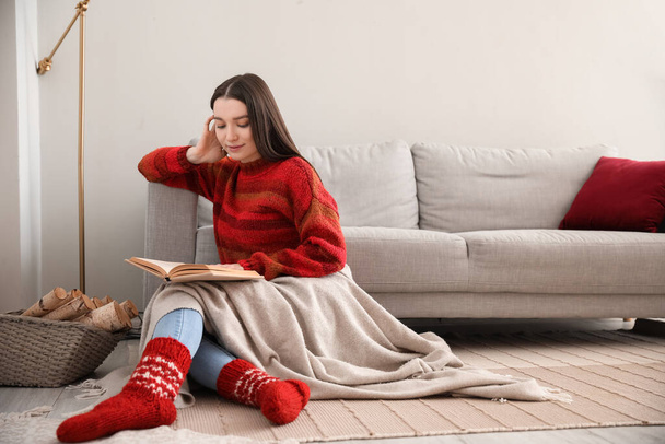 Mujer joven en jersey cálido libro de lectura en casa - Foto, Imagen