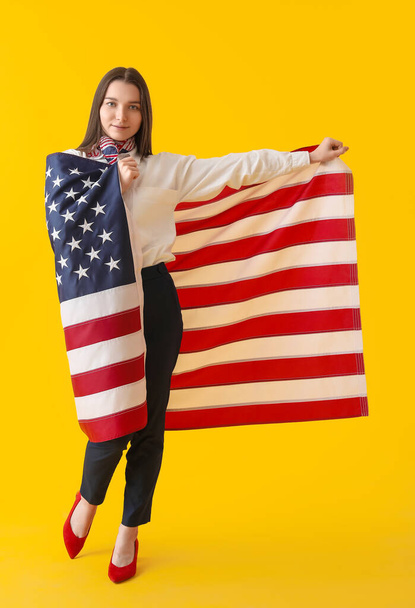 Young woman with USA flag on yellow background - Foto, Imagem