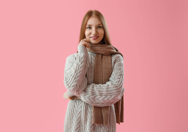 Young redhead woman in warm clothes on pink background - Photo, Image