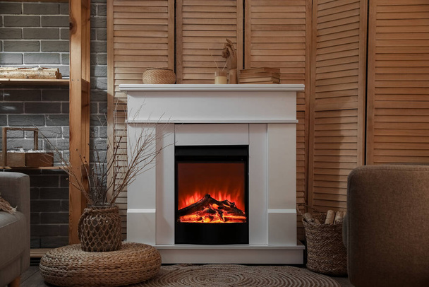 Modern electric fireplace in interior of dark living room - Φωτογραφία, εικόνα