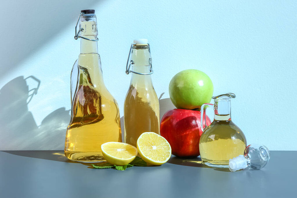 Garrafas de vinagre de maçã e frutas no fundo de cor - Foto, Imagem