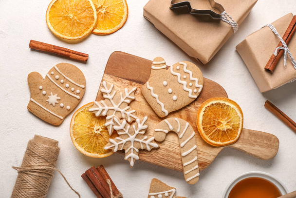 Komposition mit leckeren Weihnachtsplätzchen, Geschenken und Orangenscheiben auf hellem Hintergrund - Foto, Bild