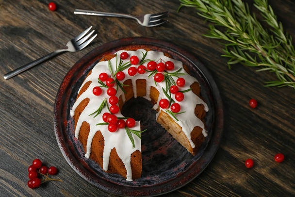 Πιάτο με νόστιμο χριστουγεννιάτικο κέικ σε σκούρο ξύλινο φόντο - Φωτογραφία, εικόνα