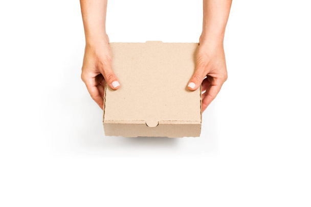 Femme tenant une boîte en carton marron avec les deux mains sur un fond blanc avec espace de copie - Photo, image