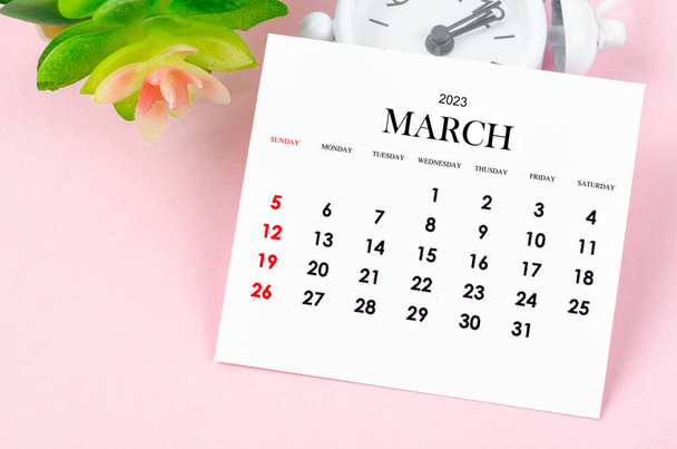 Март 2023 Ежемесячный календарь на 2023 год с винтажными будильниками на розовом фоне. - Фото, изображение