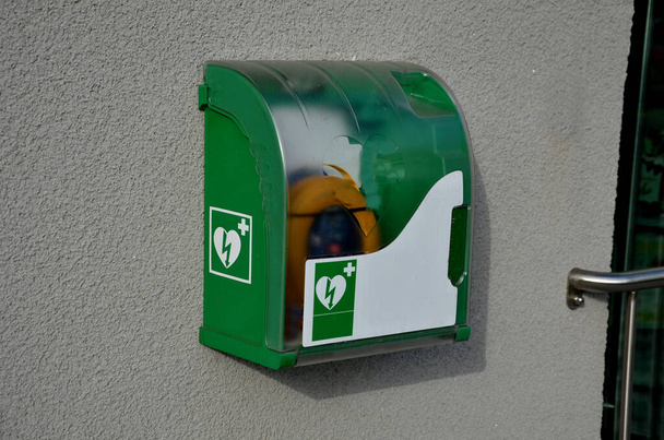 Pierwsza pomoc AED defibrylator ścienny szafka w metalowym transpa z tworzywa sztucznego jest kluczowym uchwytem drzwi, pasuje do wszystkich marek kardiologii dla miejsca publicznego, plastikowe pudełko, park publiczny, ulica, restauracja  - Zdjęcie, obraz