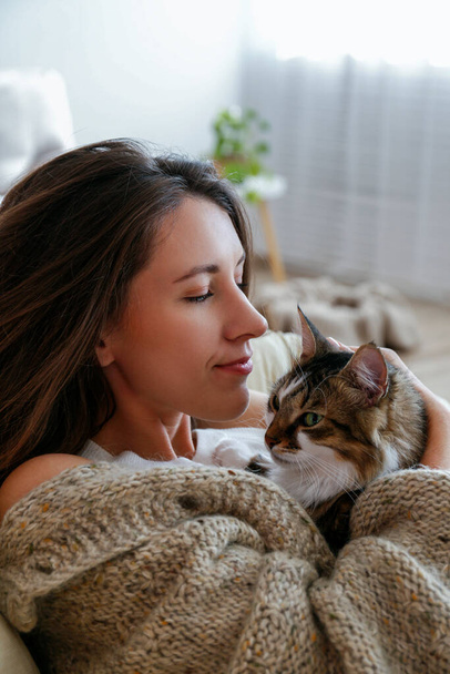 Portrait of young woman holding cute norwegian cat with green eyes. Female hugging her cute long hair kitty. Background, copy space, close up. - Foto, immagini