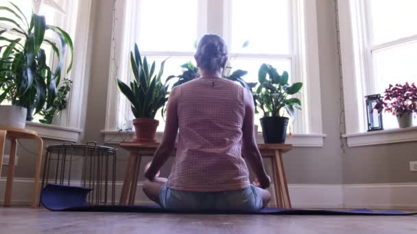 Young woman indoors practicing yoga wellness healthy lifestyle stress mundfullnes  - Footage, Video