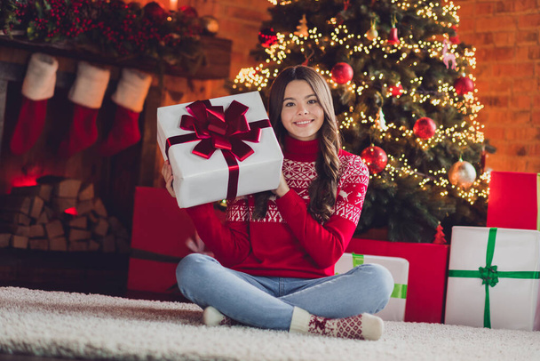 Photo of pretty joyful lady teen sit fluffy carpet floor show santa claus gift box package rejoice good time enjoy day room house indoors. - Foto, afbeelding