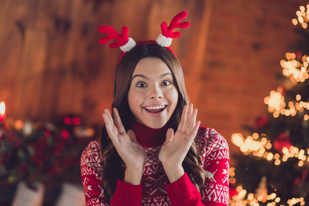 Photo of adorable astonished impressed good mood girl with brunette hair wear red ornament jumper raise hands staring in house indoors. - Foto, Imagem
