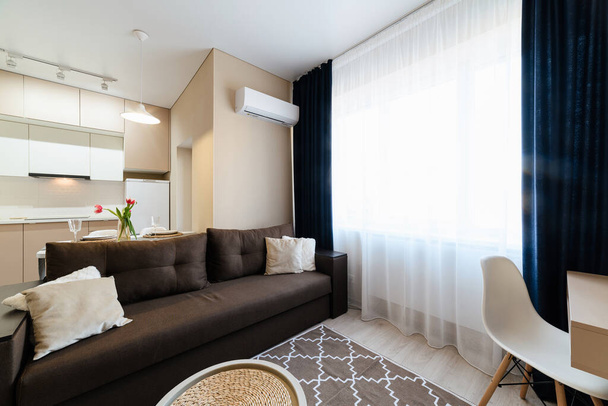 elegante y moderno diseño interior de una habitación con una gran ventana y muebles - Foto, Imagen