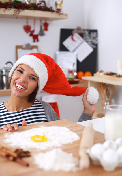 Happy young woman smiling happy having fun with Christmas preparations wearing Santa hat - Foto, Imagem