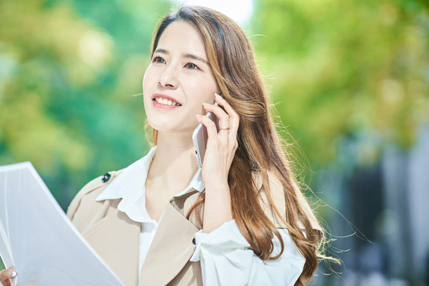 Mujer joven hablando en el teléfono inteligente al aire libre
 - Foto, Imagen