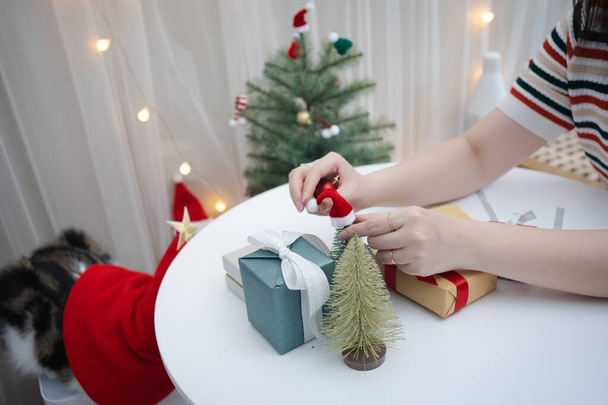 γυναίκα χέρι διακοσμούν χριστουγεννιάτικο δέντρο και το νέο έτος κουτί δώρου - Φωτογραφία, εικόνα