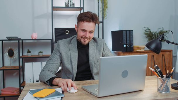 Businessman freelancer at office workplace, start working on laptop computer at desk. Professional manager freelancer man guy works on notebook, sends messages makes online purchases watching movies - Фото, зображення