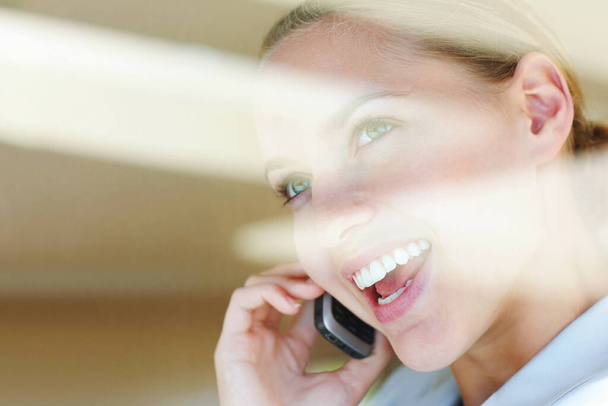 Cep telefonuyla konuşan mutlu bir bayanın görüntüsü. Camdan bakın - mutlu genç bayan cep telefonuyla konuşuyor - Fotoğraf, Görsel