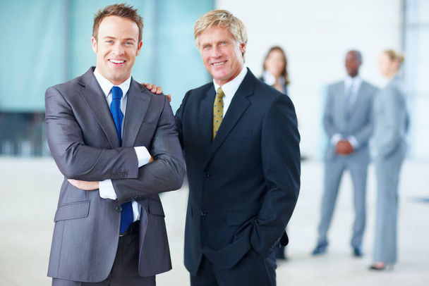 Ejecutivos masculinos sonrientes con colegas. Retrato de hombres ejecutivos felices sonriendo con colegas de fondo - Foto, imagen