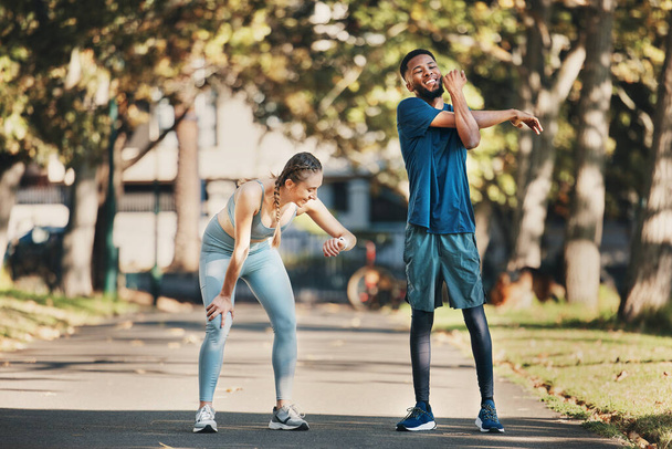 Fitness, stretching and couple rest in park after running, exercise and workout together in city. Health, wellness and interracial couple and doing training, sports and check time for performance. - Fotó, kép