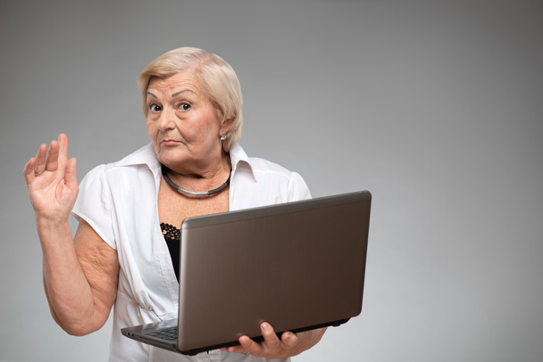 Elderly woman holding the laptop - Fotó, kép