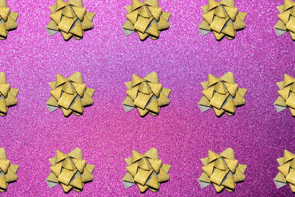 patroon van goud glitter ster lint op een roze glitter achtergrond voor uw feestelijke kerstproject - Foto, afbeelding