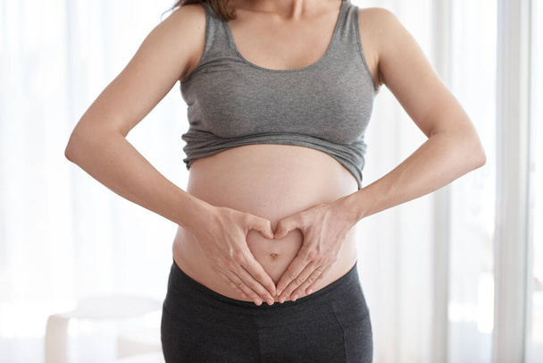 Schwangerschaft ist schön. eine schwangere Frau steht in ihrem Haus - Foto, Bild
