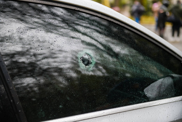 Dnipro, Ukrajina 17.listopadu 2022: Poškozené okno auta úlomkem explodující střely. Díra v okně. - Fotografie, Obrázek