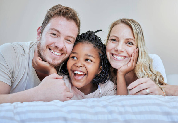Çeşitlilik, mutlu aile ya da koruyucu aile yatak odasında rahatla, mutlu ol ya da aile içinde aşk portresi yap. Anne, baba ve siyah kız mutlu olmak için yatakta gülümsüyor, kaliteli zaman ve destek için. - Fotoğraf, Görsel