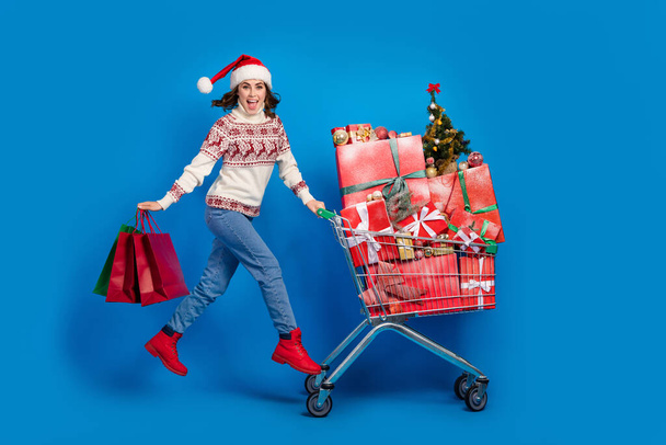 Full length photo of cheerful lady buy deliver many presents step walk mall center market decor shop isolated on blue color background. - Φωτογραφία, εικόνα