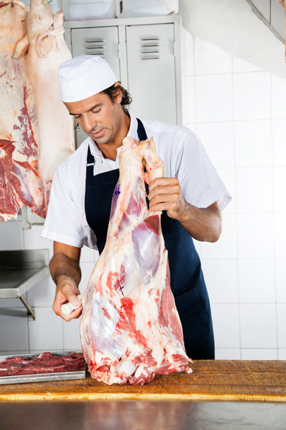 Macellaio con carne che lavora al bancone
 - Foto, immagini