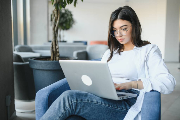 Beautiful Caucasian woman dreaming about something while sitting with portable net-book in modern cafe bar, young charming female freelancer thinking about new ideas during work on laptop computer. - Φωτογραφία, εικόνα