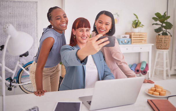 Teamwork, phone and business woman taking selfie on break, relax and smile in creative workspace. Support, collaboration and happy female workers using smartphone for picture in eco friendly office. - Zdjęcie, obraz