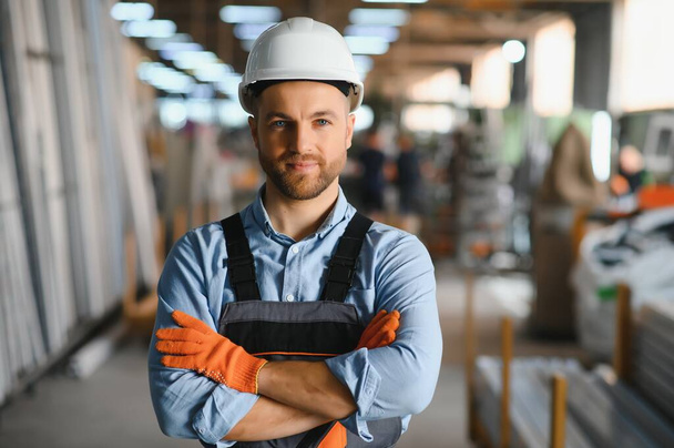 Portrait of smiling worker standing by industrial production machine - Foto, Bild