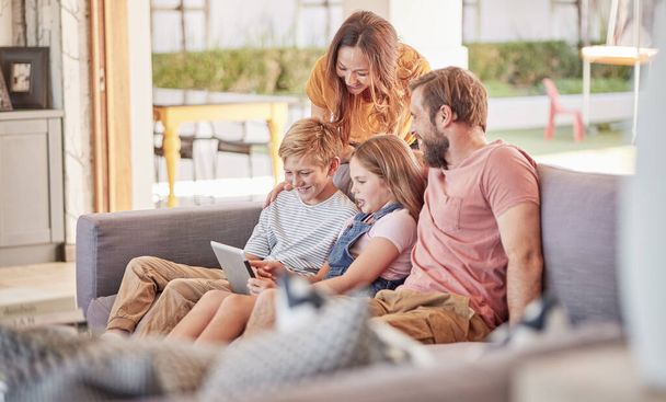 Parents, children and digital tablet on sofa in house or family home living room for movie, internet game or streaming. Smile, happy and bonding woman, man and kids with technology or subscription. - Fotografie, Obrázek