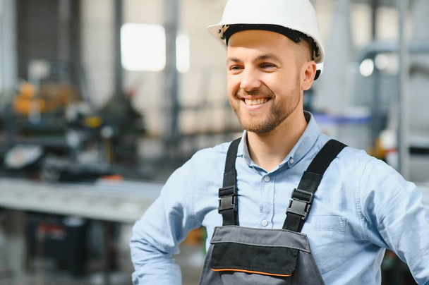 Portrait of smiling worker standing by industrial production machine - Foto, Imagem