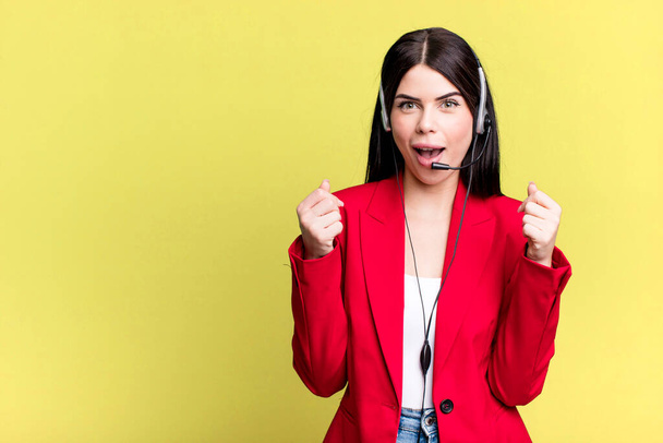 feeling shocked,laughing and celebrating success. telemarketer with a headset concept - Foto, Imagen