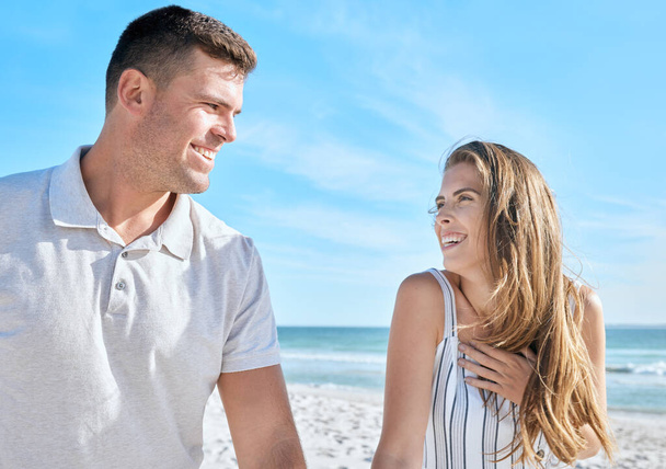 Love, beach relax and couple on vacation, holiday or summer trip. Romance, travel and man and woman talking, having fun and enjoying quality time together outdoors on sandy seashore or ocean coast - Valokuva, kuva
