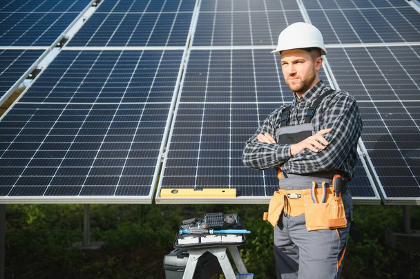 Worker installing solar panels outdoors. - Photo, image