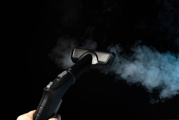 Disinfection with a steam cleaner. Steam on a black background. - Zdjęcie, obraz