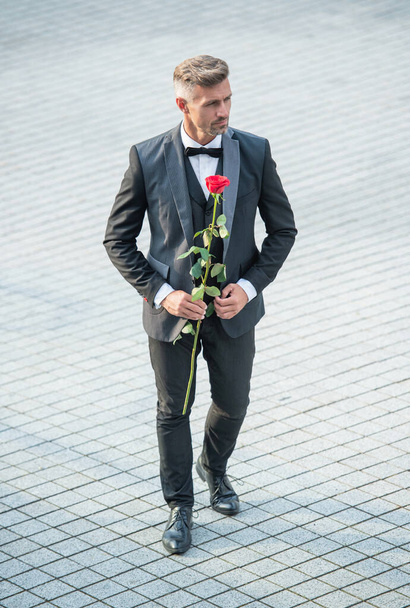 engagement date. tuxedo man celebrates engagement. man with rose gift for engagement. full length. - Fotoğraf, Görsel