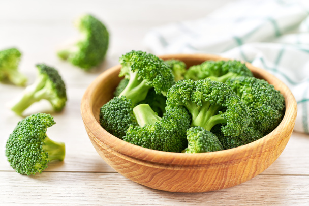 čerstvá organická brokolice v misce na bílém dřevěném stole. - Fotografie, Obrázek