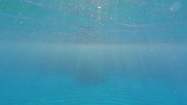 Los rayos del sol atraviesan el agua azul transparente - Imágenes, Vídeo