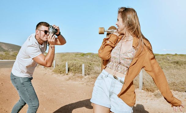 Photo, skateboard and couple on a road trip in nature to travel during summer. Photographer, love and man with a vintage camera and picture of an influencer ready for skateboarding in countryside. - Фото, изображение